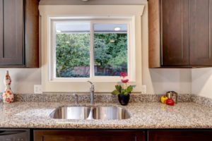 dark brown kitchen cabinet with sink and granite counter